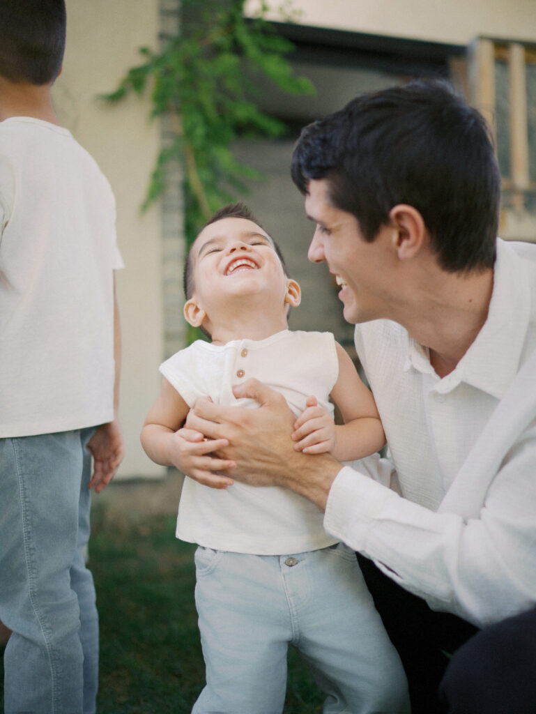 Dad laughing with his son during family photos