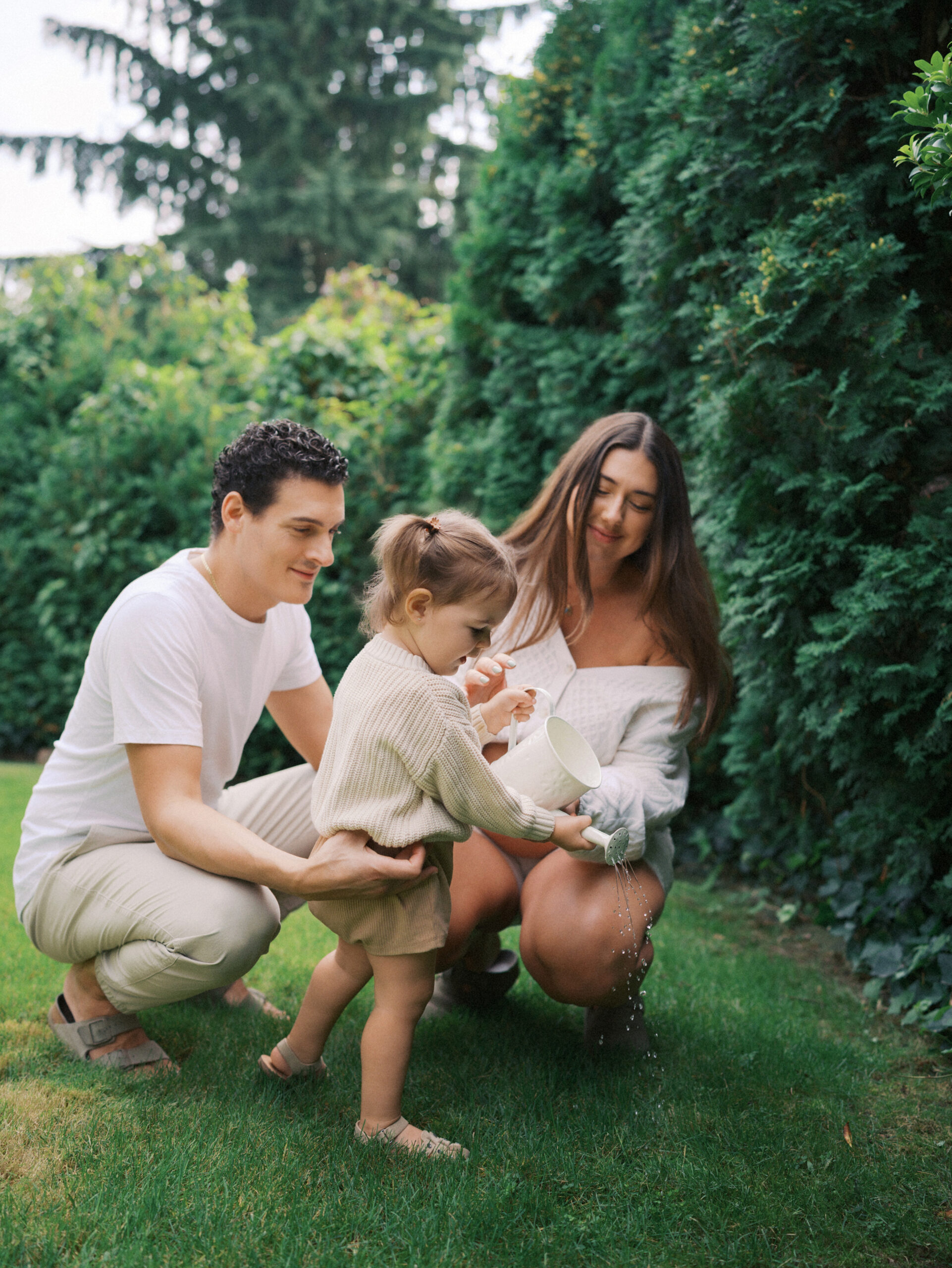 Family hanging out together in their Vancouver home backyard while watering the plants